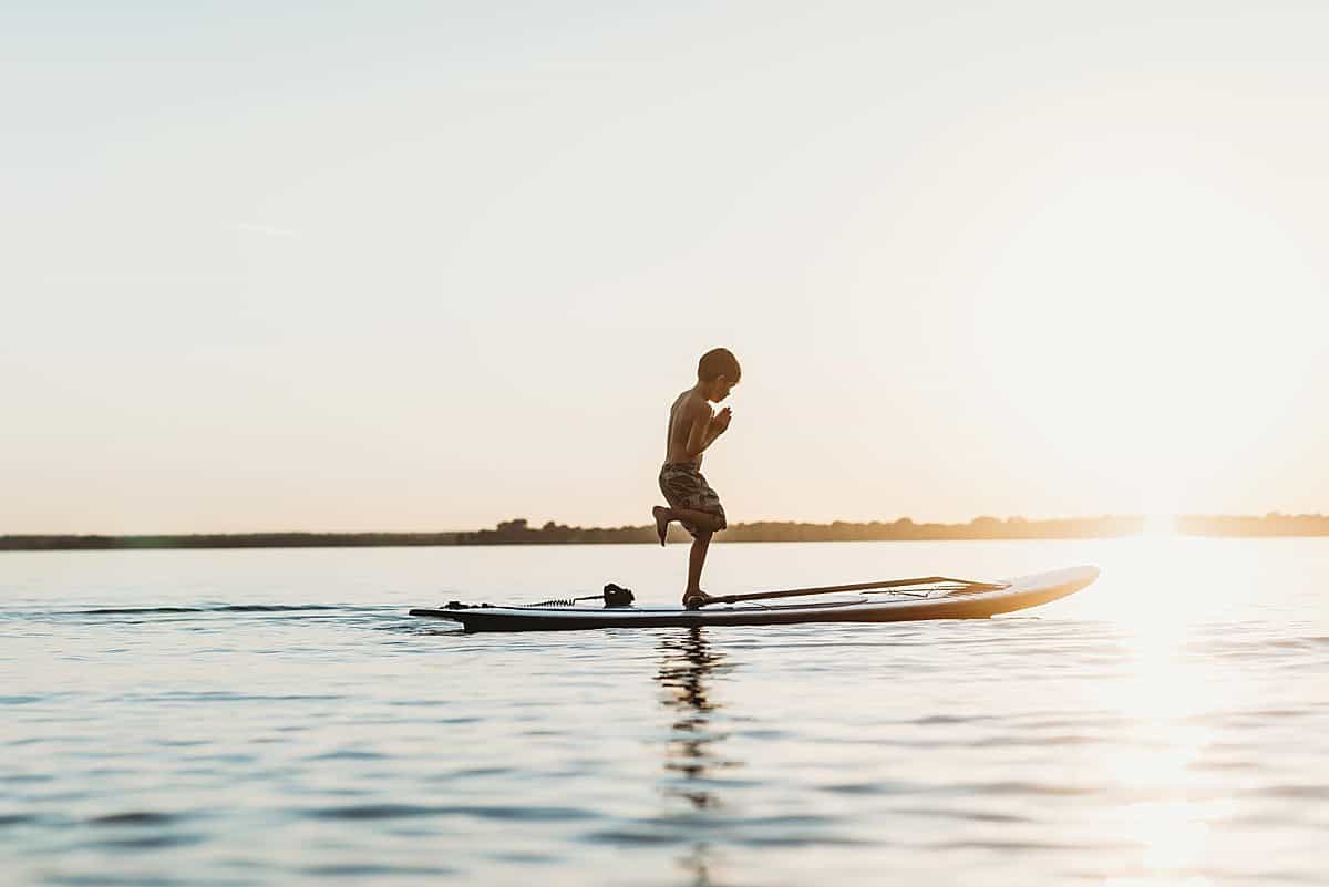 kids doing yoga on a stand up paddle board - best outdoor water sports for kids