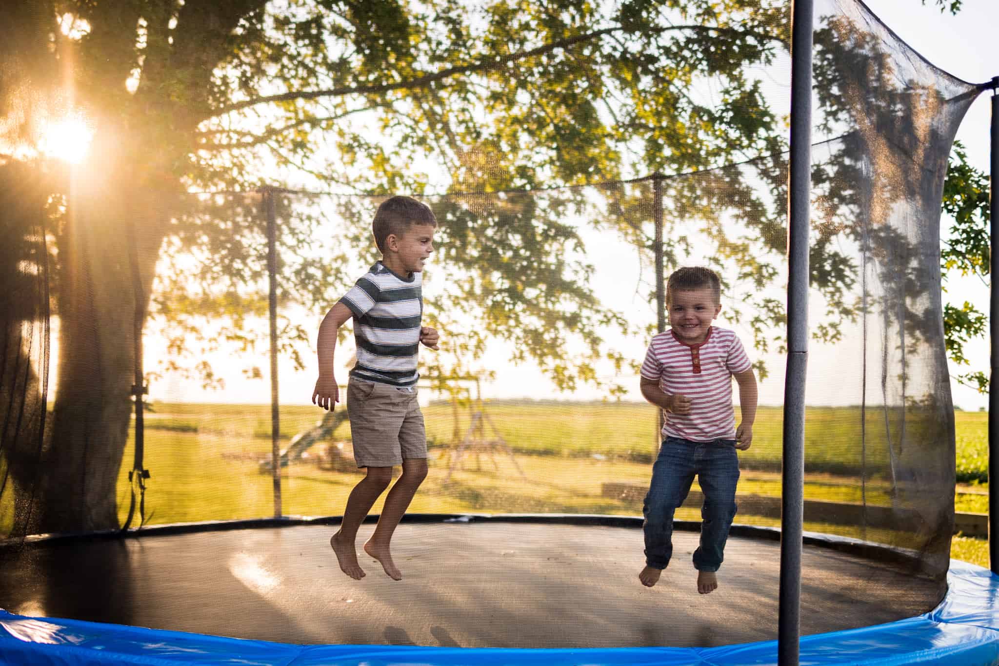 Two boys jumping on a trampoline