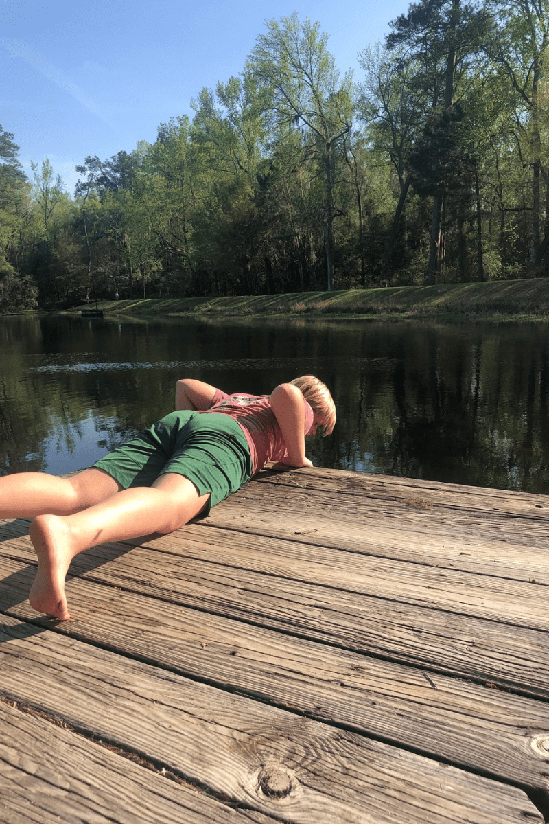 boy laying face down on a dock over the edge