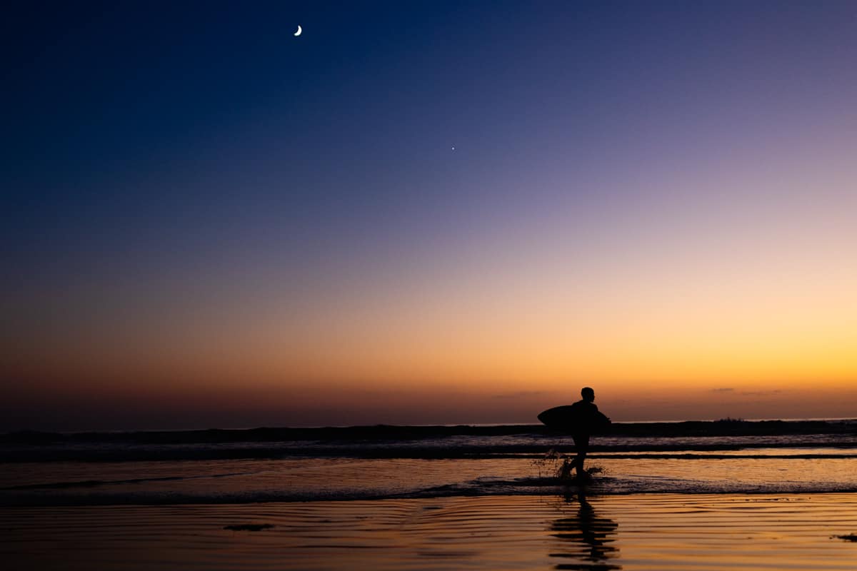 kid skim boarding at dusk