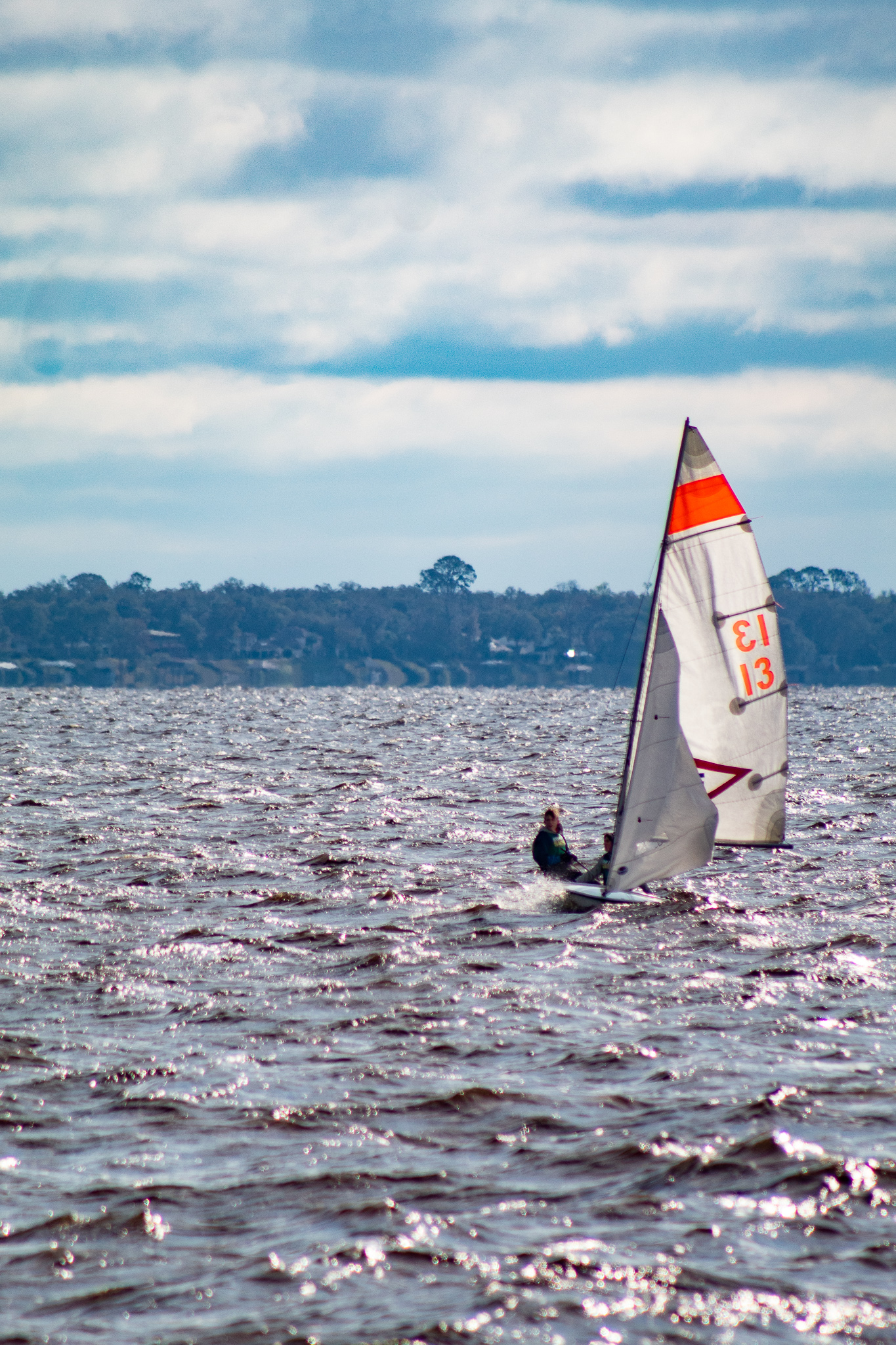 kid racing a sailboat in choppy waters