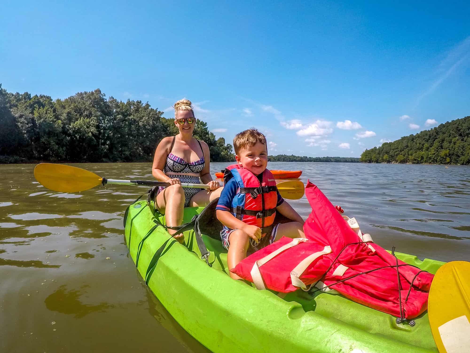 Child in kayak with life jacket on - best life jackets for kids