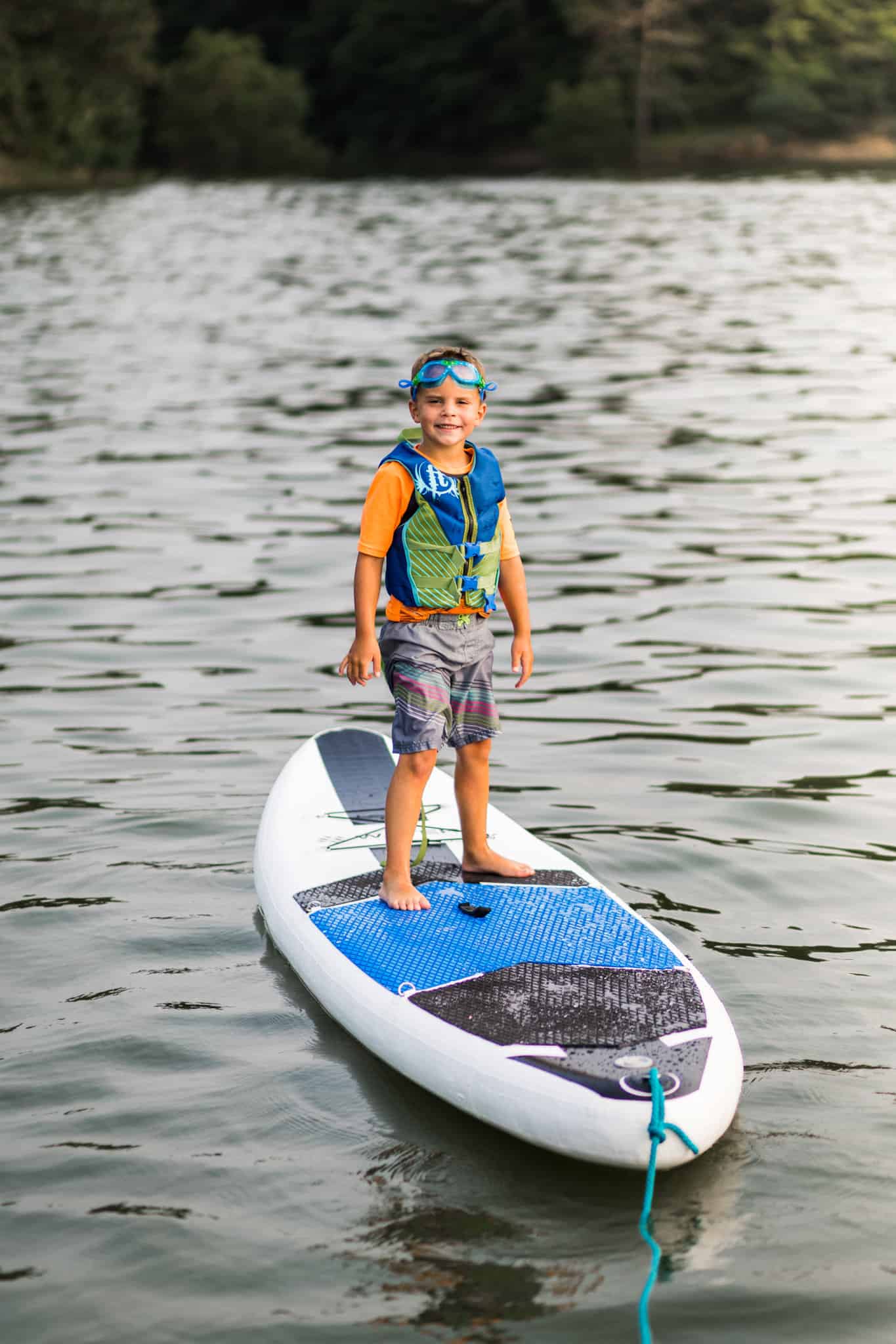 Child on paddle board in life jacket - best life jacket for water sports