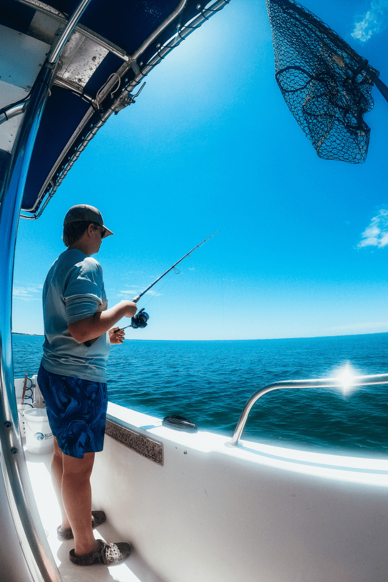 teen boy fishing off of a fishing charter boat in St. Joe's Bay