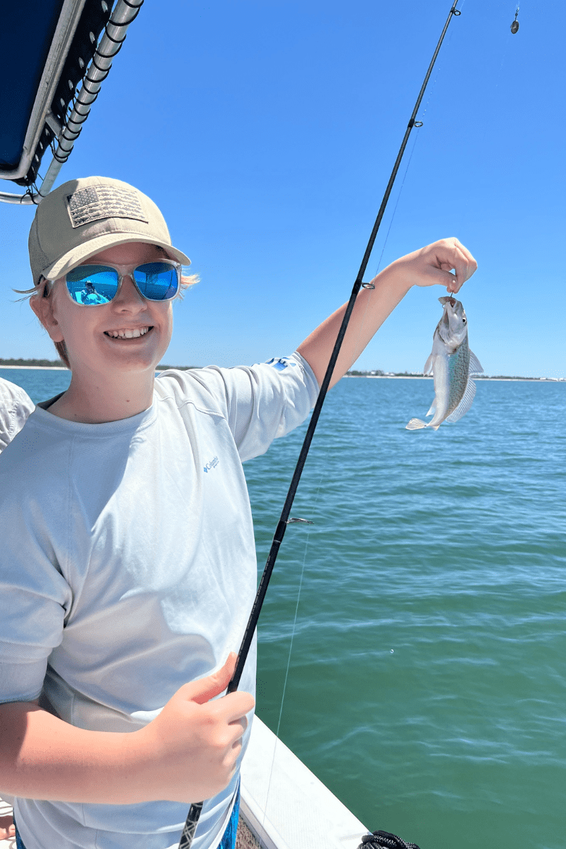 Teen boy with a small fish on a hook in the Florida Gulf