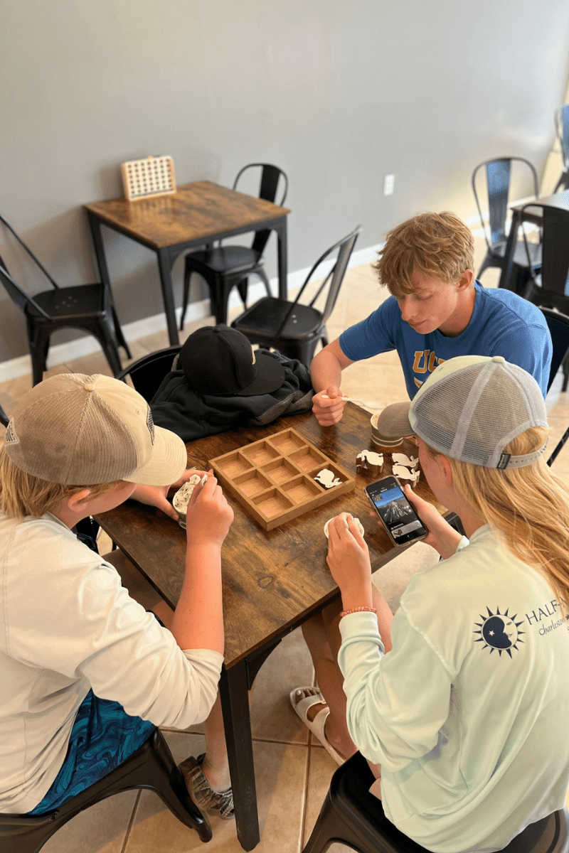 teens snacking on ice cream and playing a board game