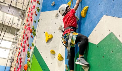young boy climbing an indoor rock wall