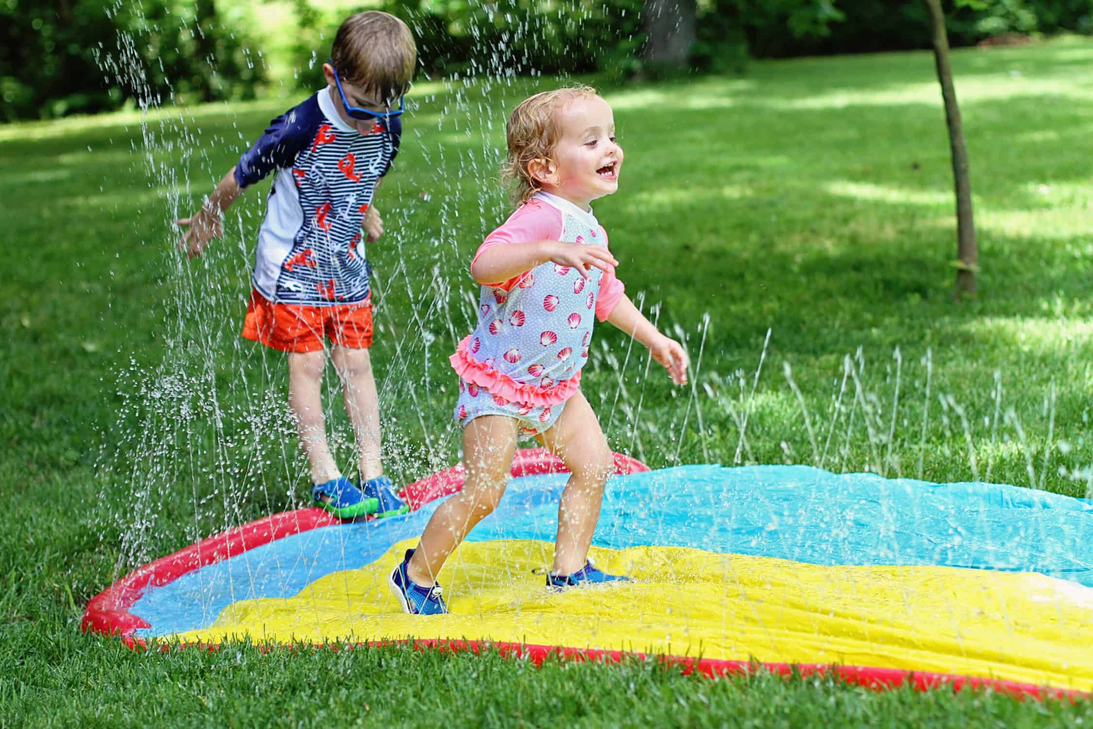 children on slip n slide with sprinkler - best water toys, games and activities for kids