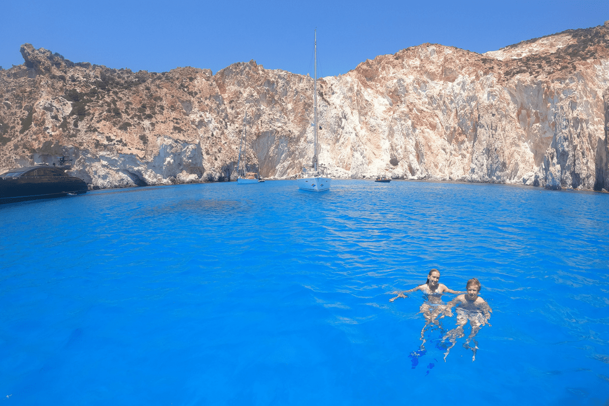 teen girl and teen boy swimming in the blue waters of the Aegean Sea in the greek islands