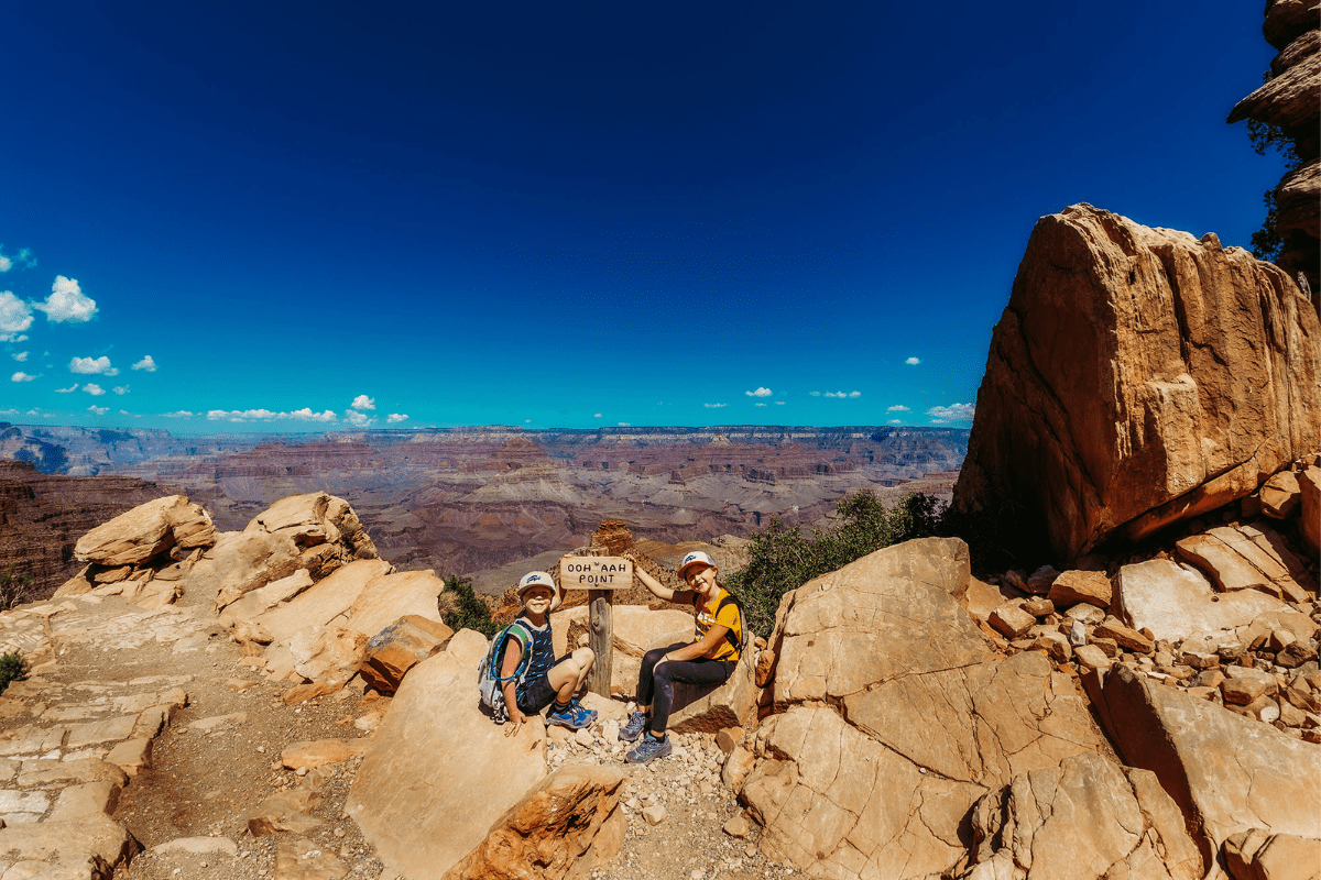 two kids at the trail sign for Oooh Ahh point in the Grand Canyon National Park