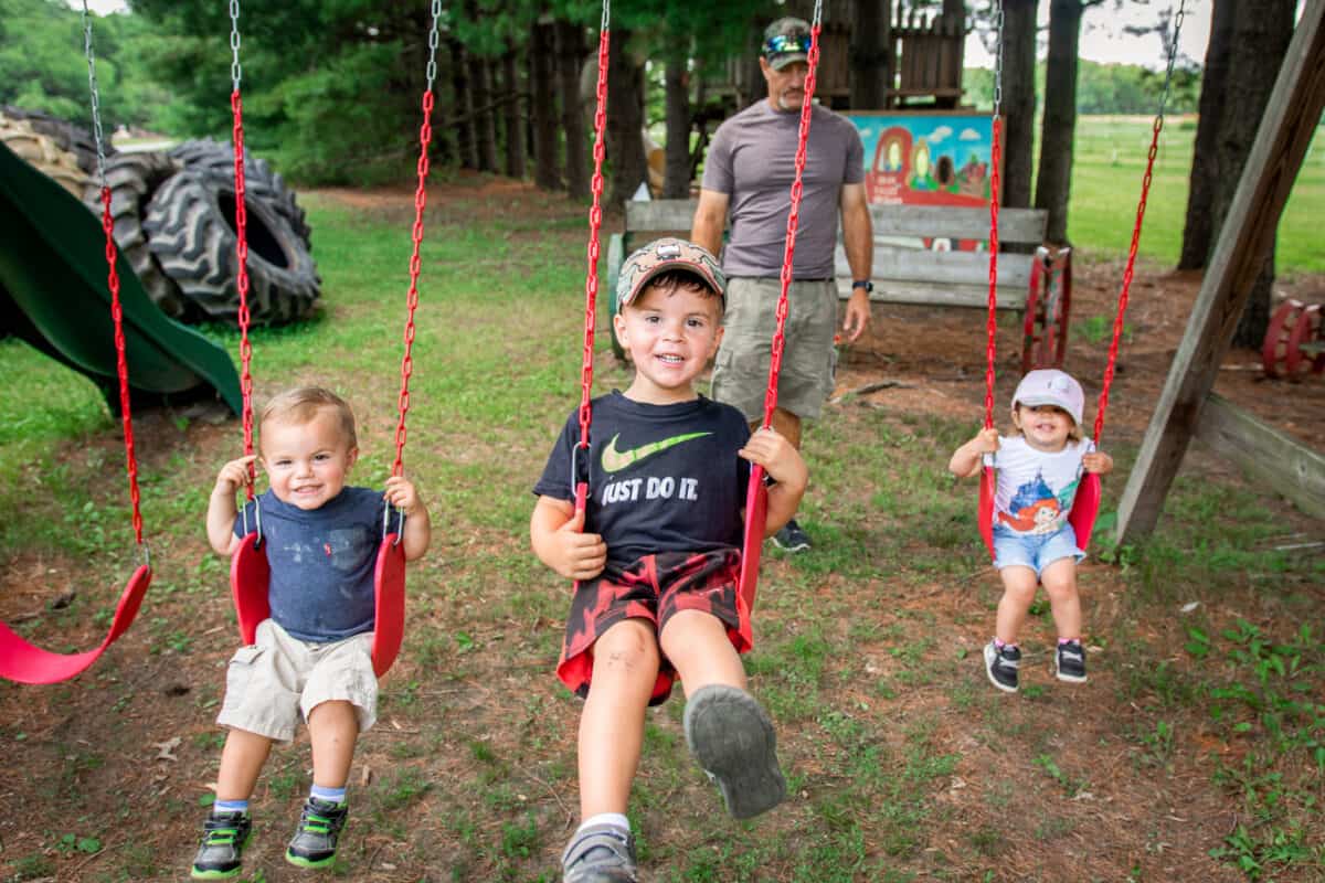 Three children on red swings - how to choose the best swing for your kids