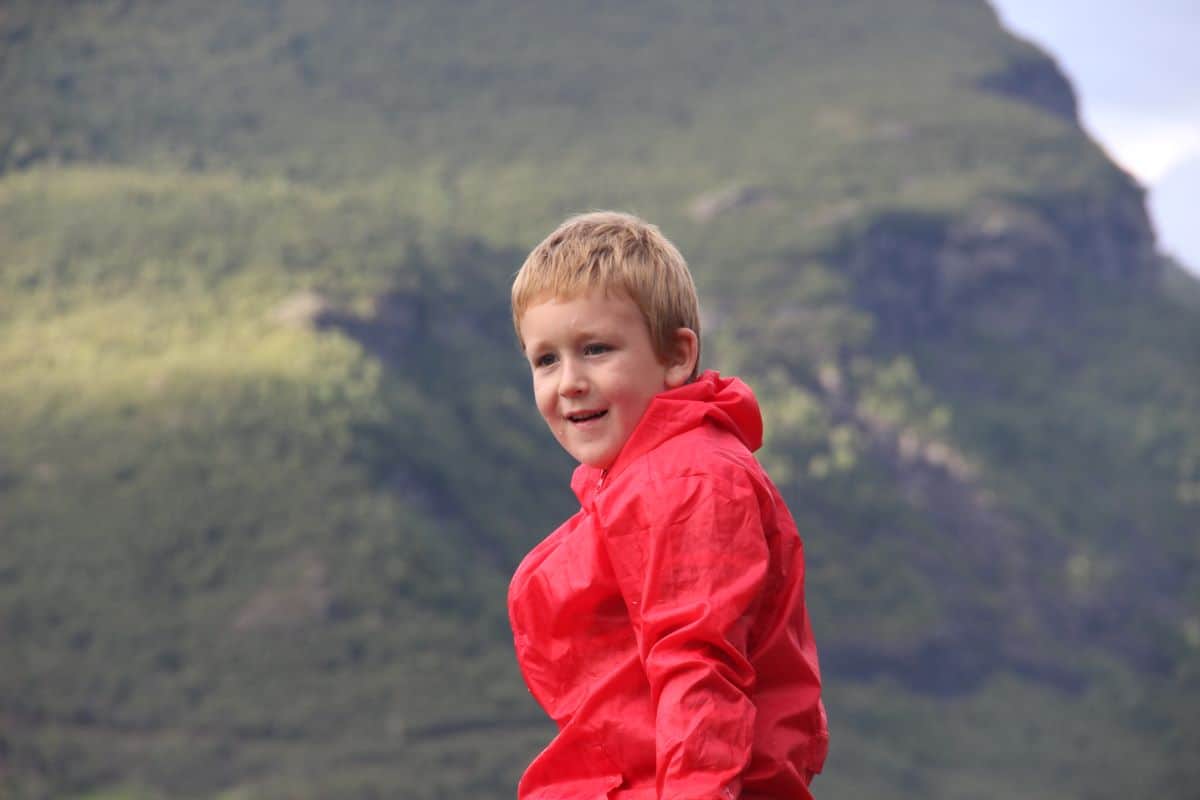 a boy with mountains in the background 