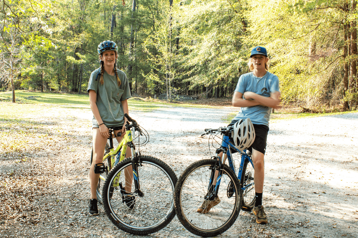 teen boy and teen girl on stationary on a mountain bike path