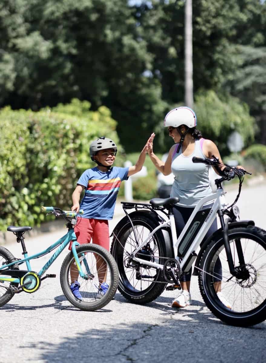 Mom and son high-fiving with an e-bike