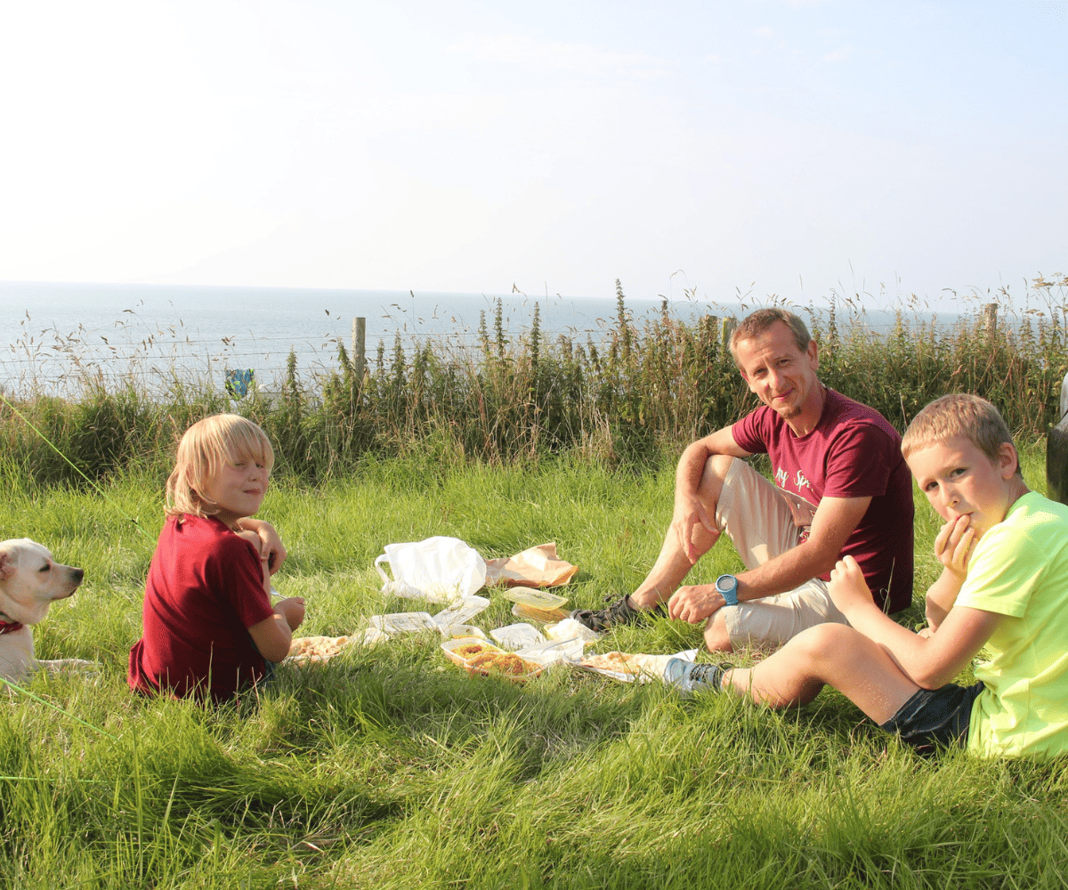 Father and sons enjoying outdoors picnic 