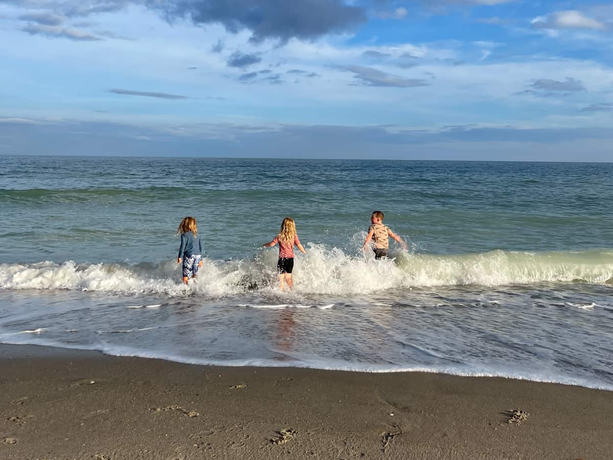 Kids playing together in the waves at the beach 