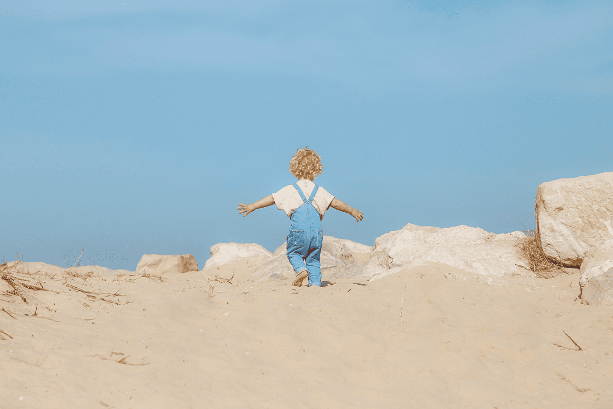 Child on beach at Mudeford Sandbank, UK - Best beaches for kids in Southern England