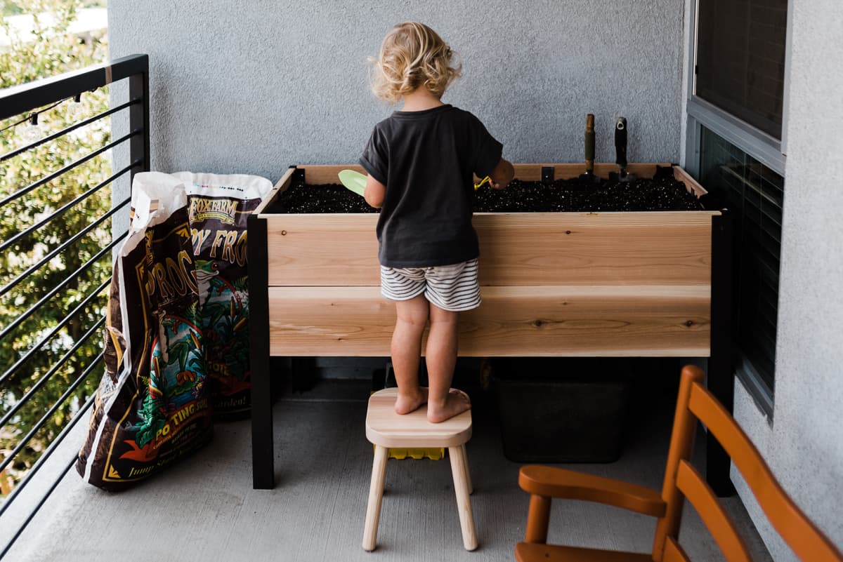Creating a themed garden for kids and examples of types of gardens your child might be interested in growing. Here a child tends to a small balcony garden.