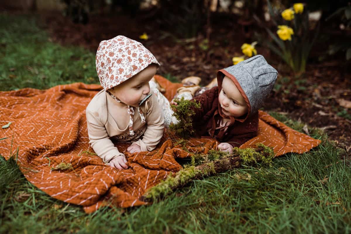 comprehensive gardening guide for parent - Twin infant girls exploring lichen on a log. 