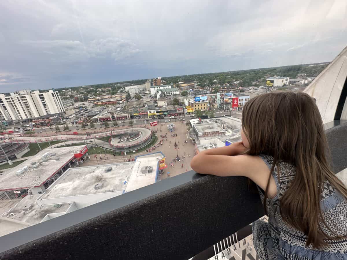 Kid looking out at Clifton Hill from the Skyview Ferris Wheel in Niagara Falls, Canada