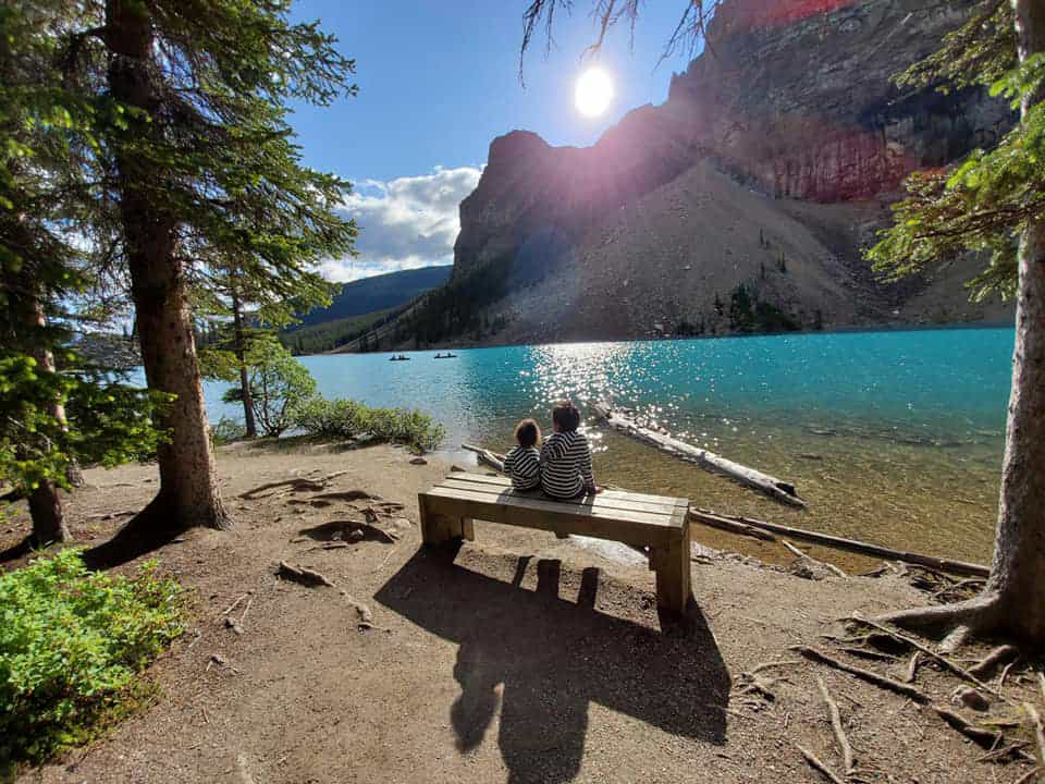 Kids rest on a bench on the Lakeshore Trail at Moraine Lake in Banff.