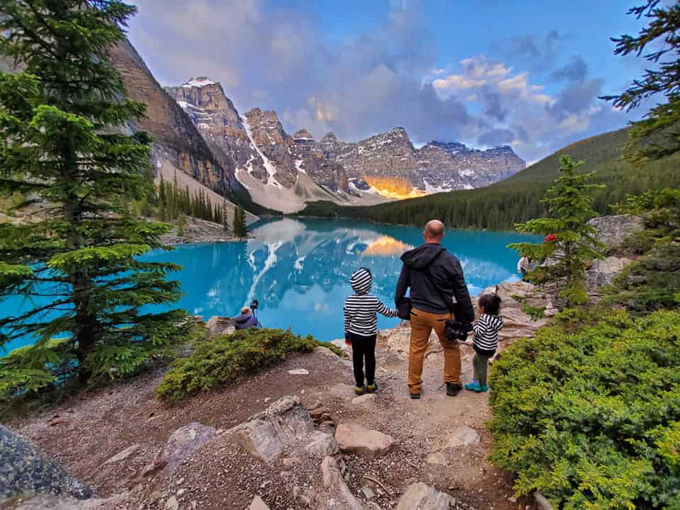 Parent and kids enjoy the view from the Rockpile at Moraine Lake in Banff National Park.