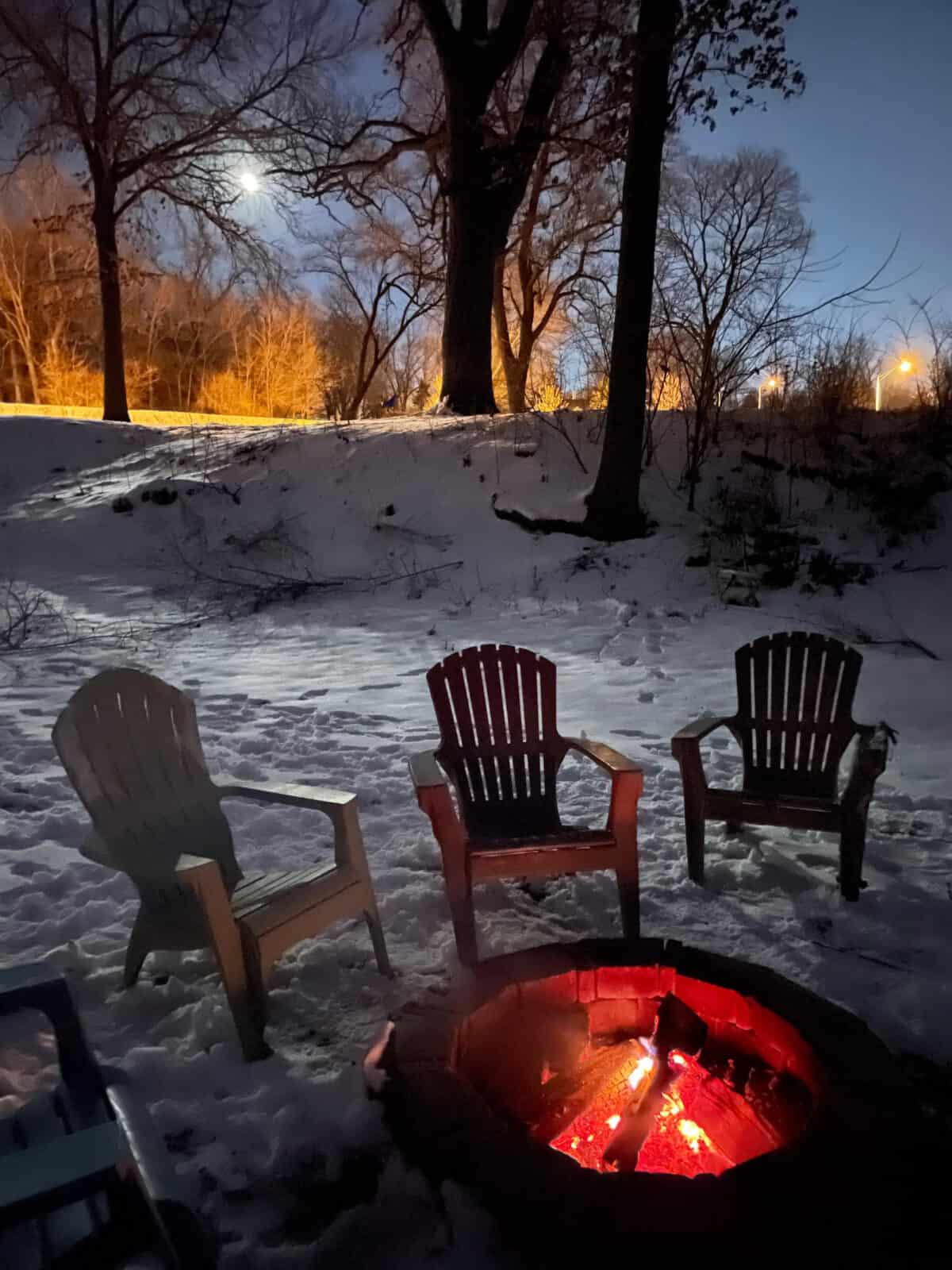 campfire in the snow with three trees