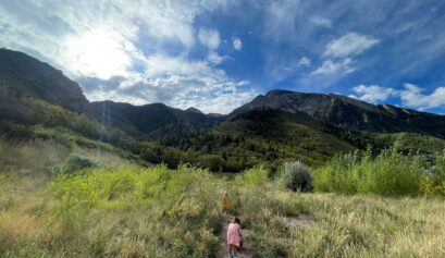 Women's History Month: Adventurers, Activists, and Nature-Lovers. Children on a hiking trail in a green and sunny canyon.