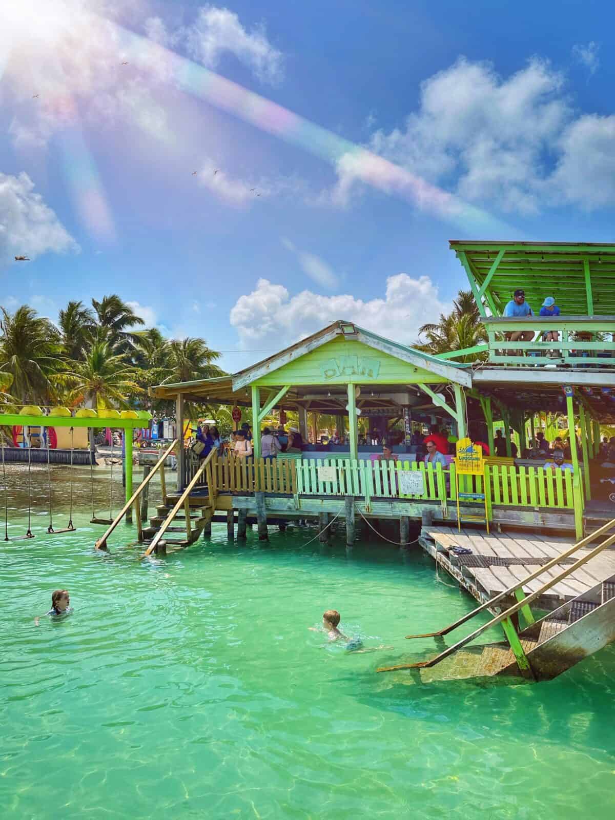 kids swimming in front of Sip N Dip restaurant and bar in Caye Caulker Belize