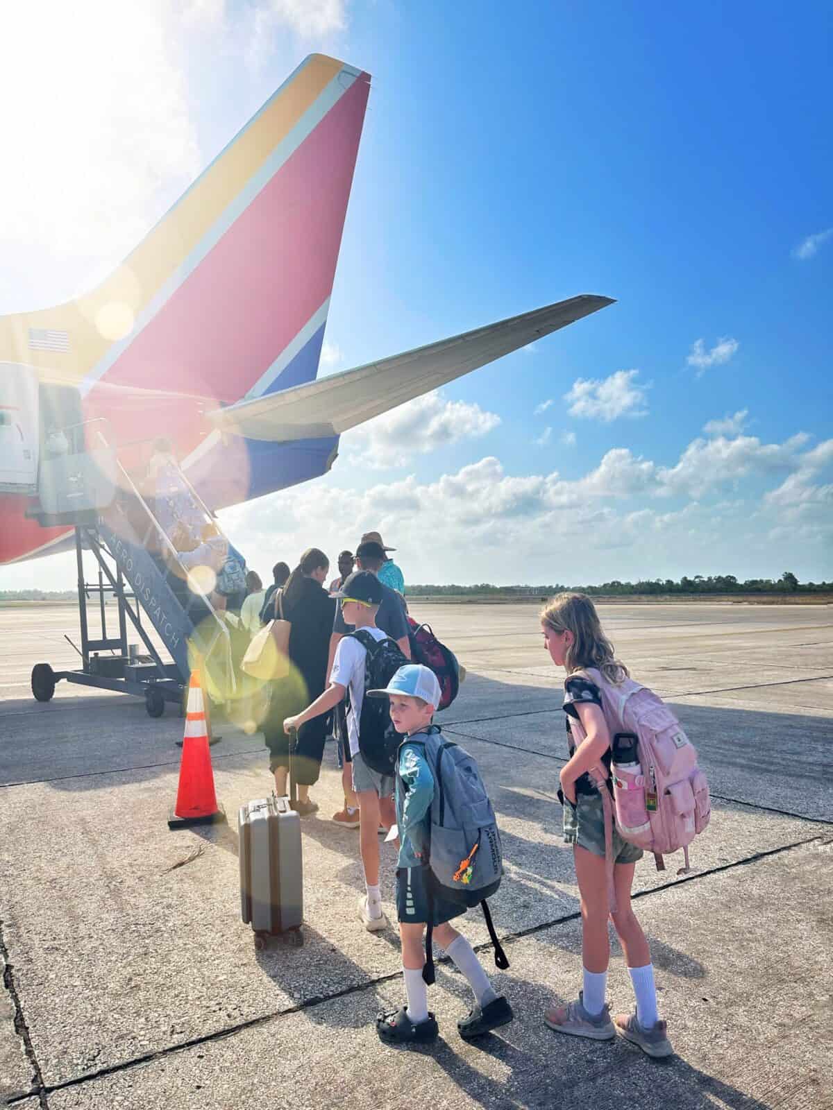 Traveling from the US to Belize is easier than you might expect - photo of kids standing in front of Southwest Airlines plane from Houston to Belize City
