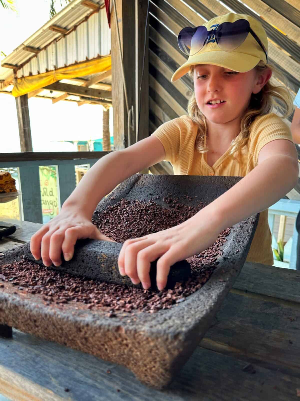 child pressing chocolate during class belize