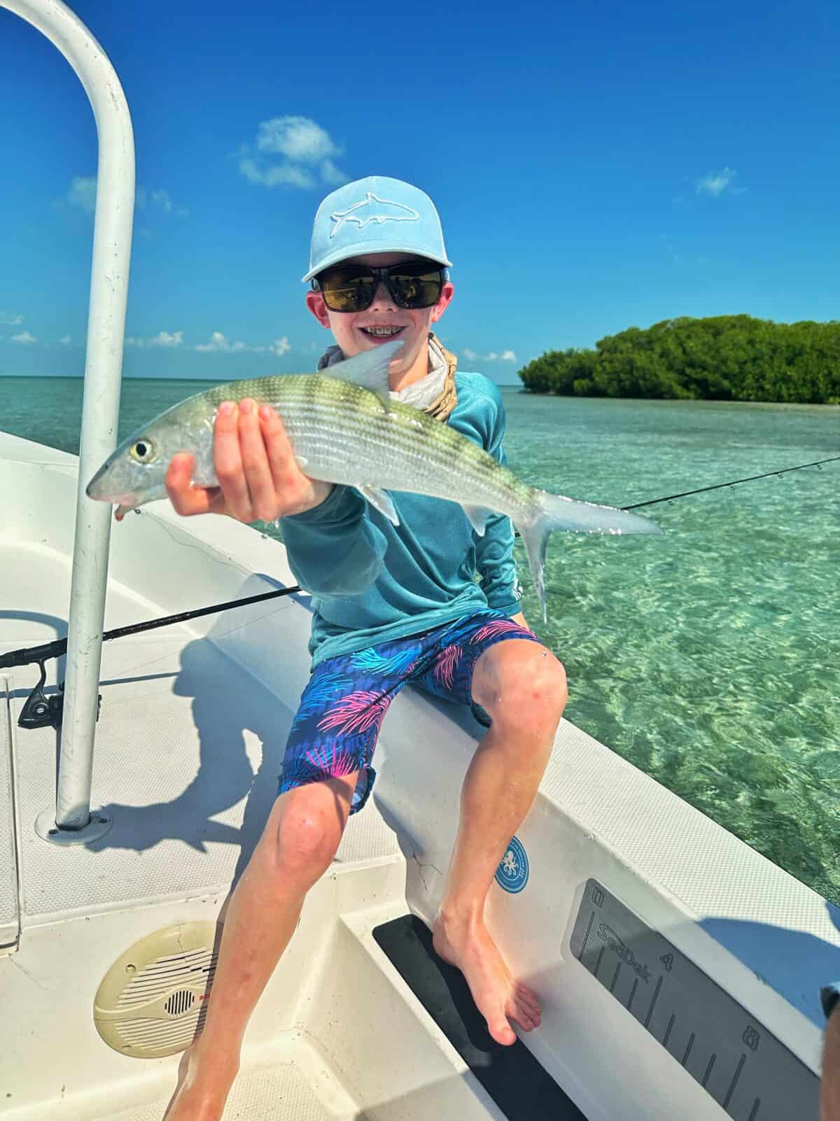kid holding a fish - fishing ambergris caye belize
