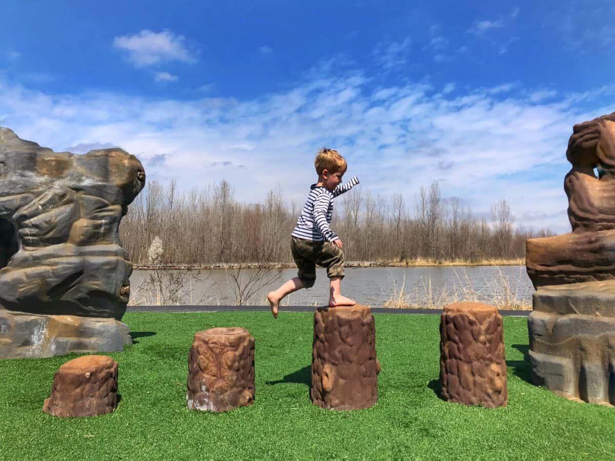 tips for raising independent kids - little boy walking across stumps outside